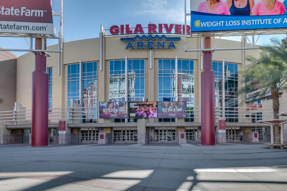 This image showcases the exterior of Gila River Arena, featuring its prominent sign, large digital screens, and the main entrance bustling with anticipation. The scene evokes the energy and excitement of live events, concerts, and major sports moments.